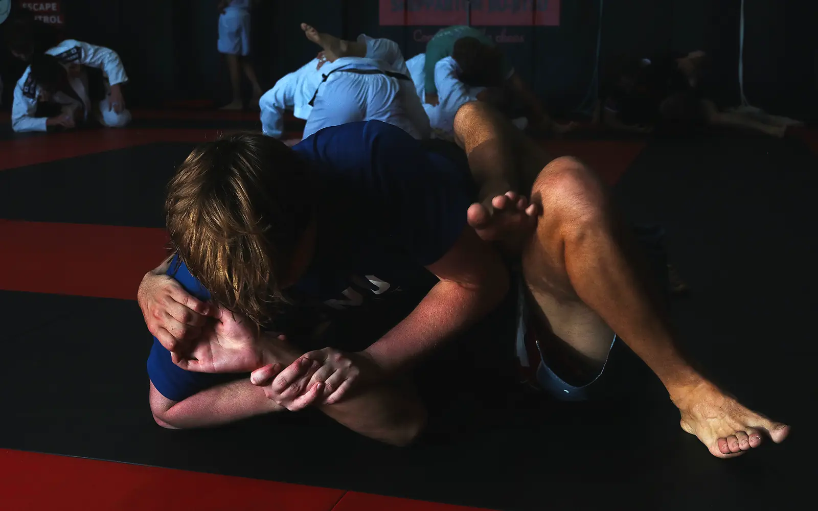 Members drilling grappling on the red and black mats at Shepparton Jiu-Jitsu